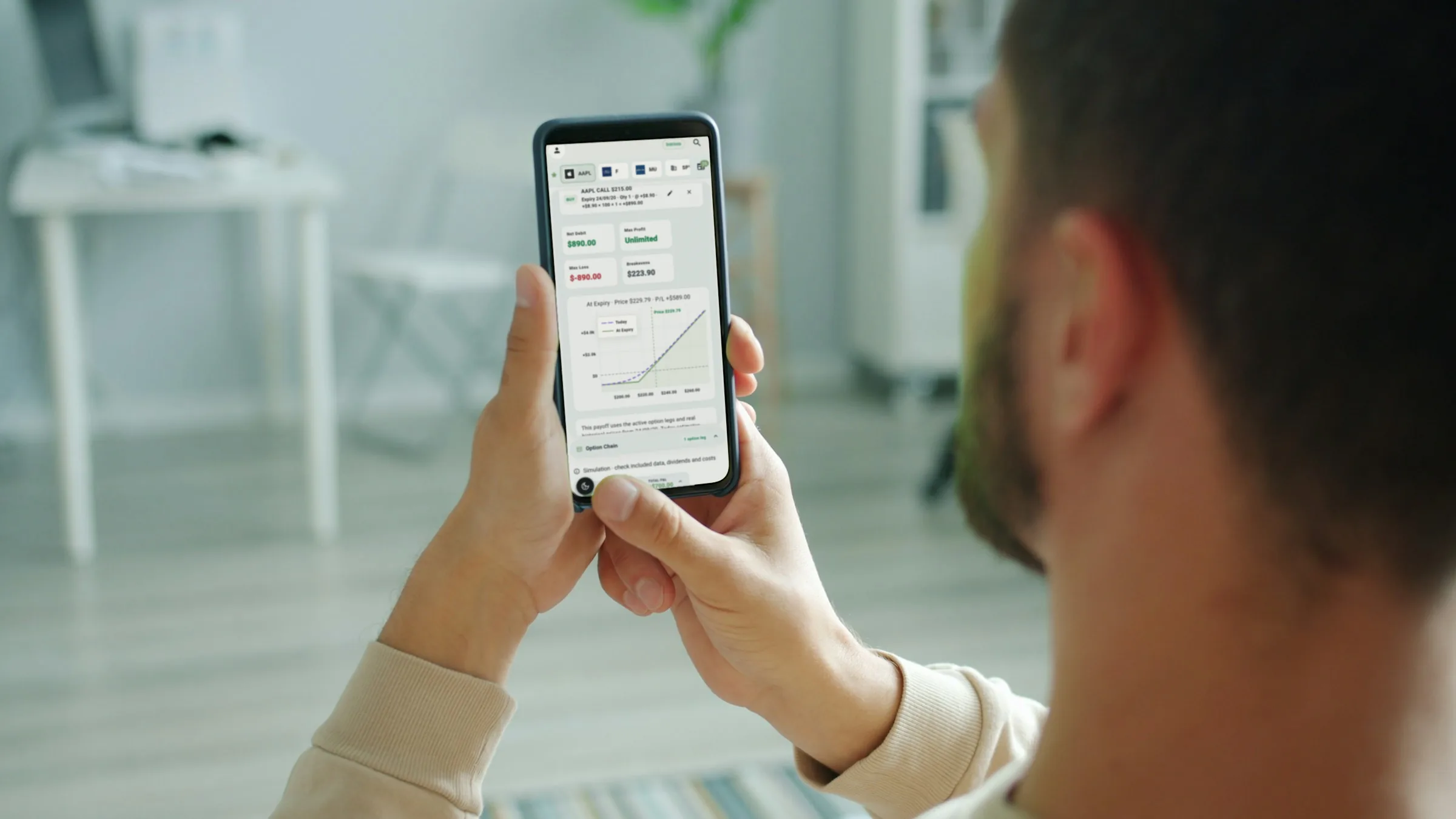 Someone reviews the payoff curve of a strategy on a phone